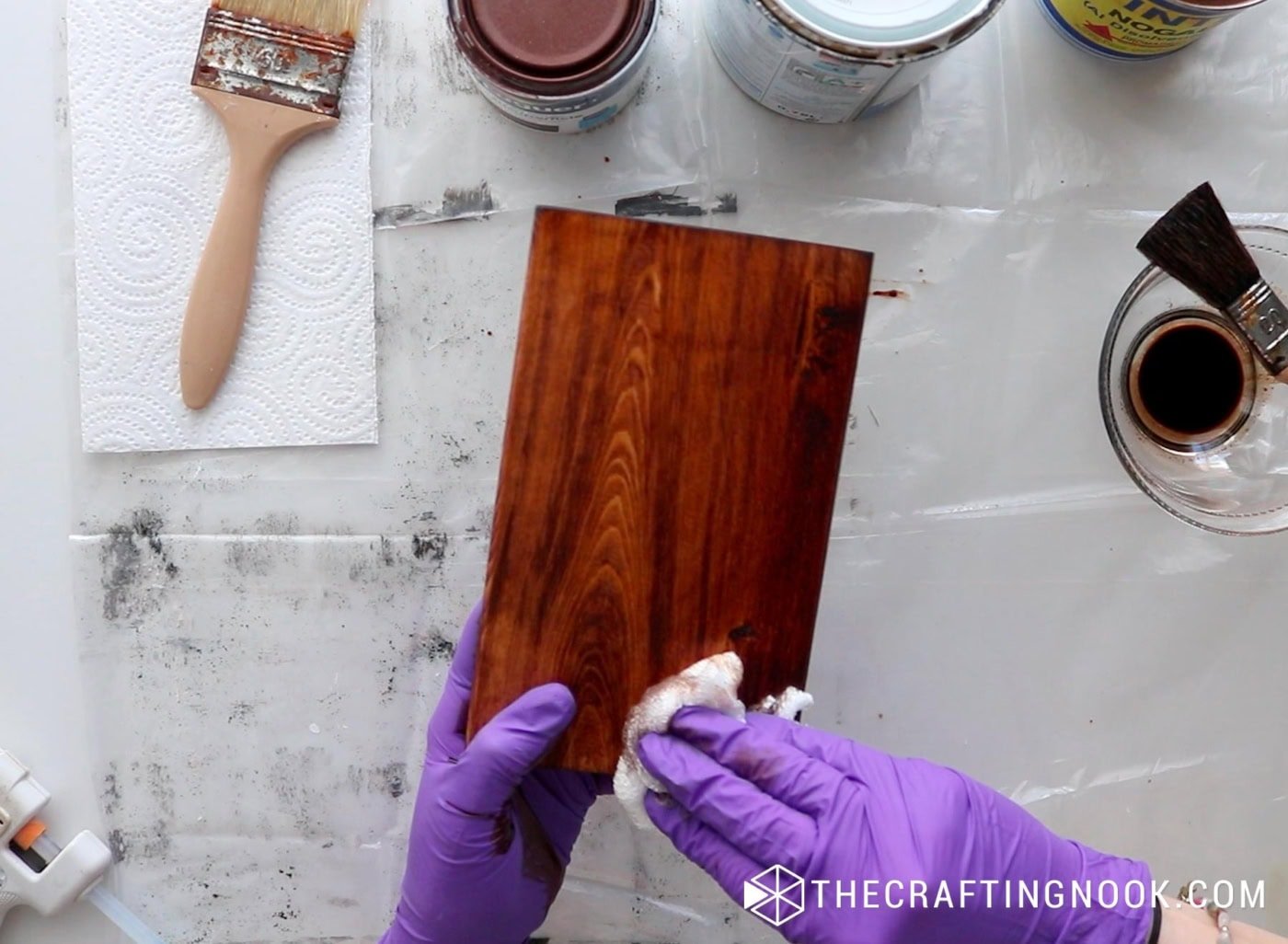 Wiping off excess wood stain from the block to reveal the grain.