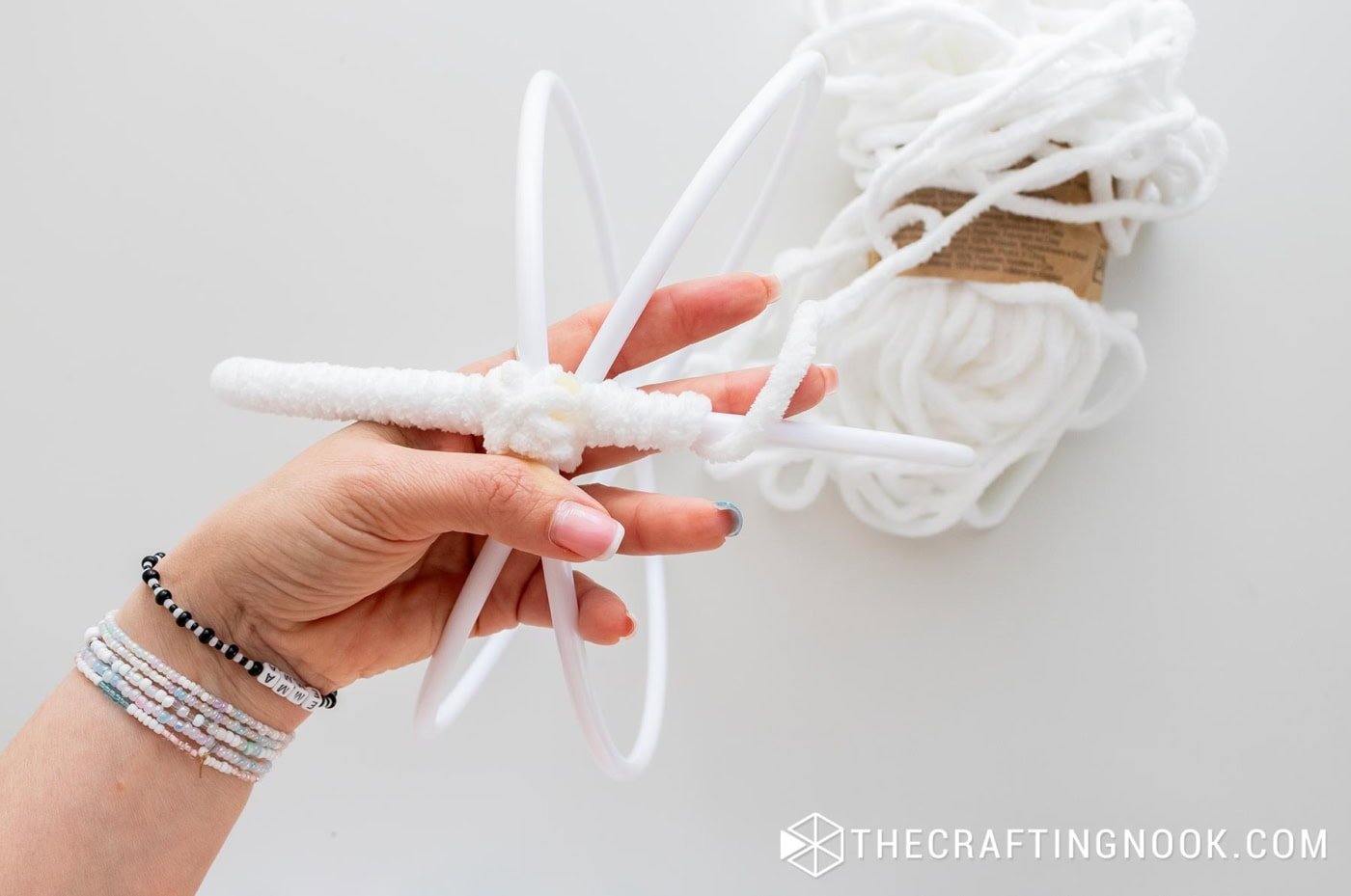 One full hoop segment completely wrapped in yarn while the rest of the frame is still uncovered.