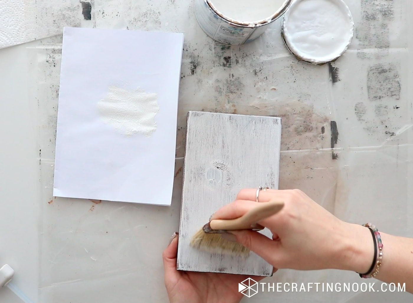 Lightly dry-brushing white paint over the stained wood block.