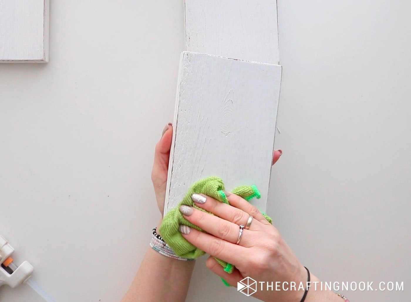 Dusting off the painted wood block with a green damp cloth.