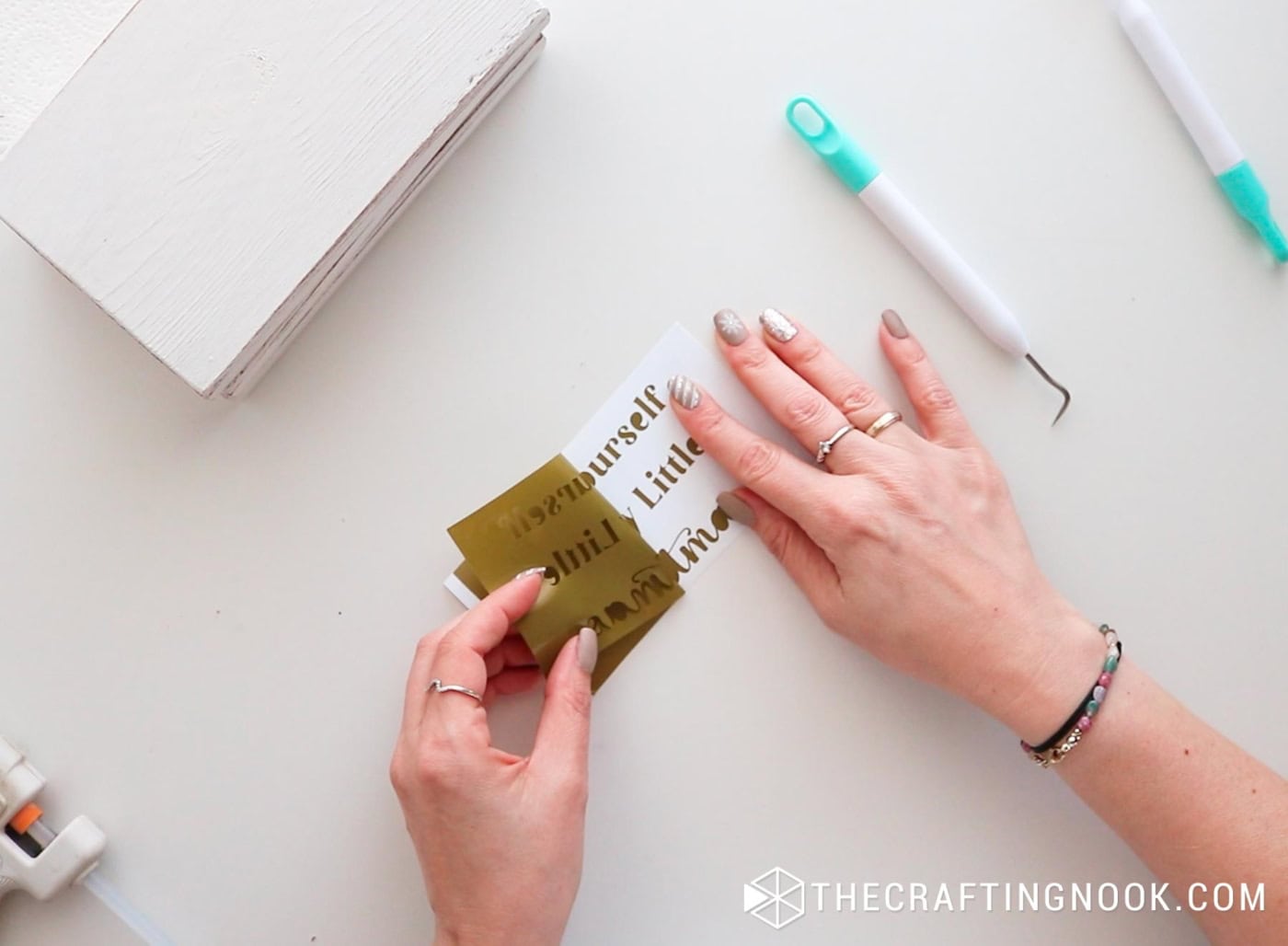 Removing excess vinyl from the gold lettered Christmas phrase.