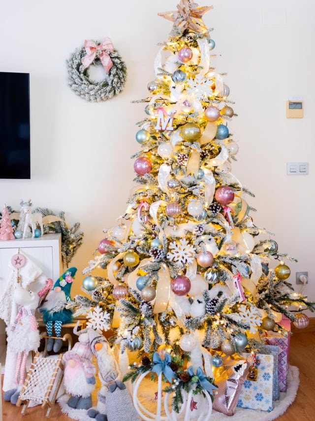 Flocked Christmas tree with pink, blue and gold ornaments, ribbon accents and handmade glitter baubles.