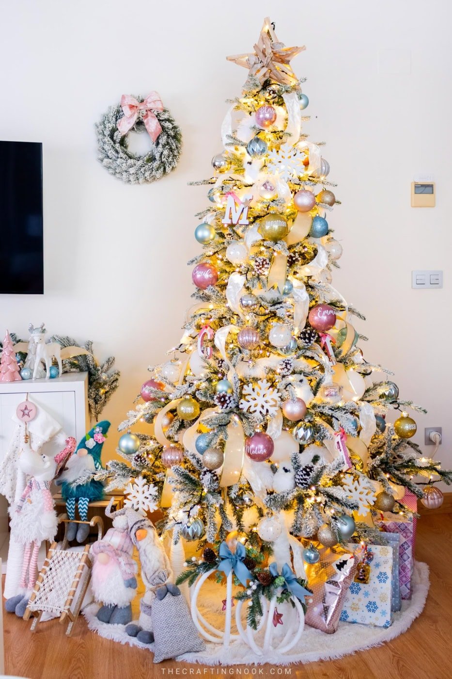 Flocked Christmas tree with pink, blue and gold ornaments, ribbon accents and handmade glitter baubles.