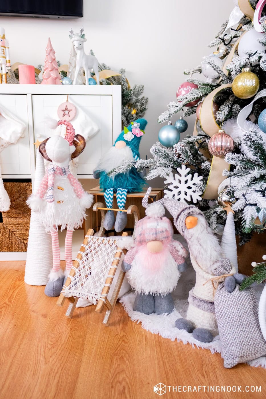 Decorated tree base with fluffy tree skirt, gnomes, sled and large hoop ornaments.