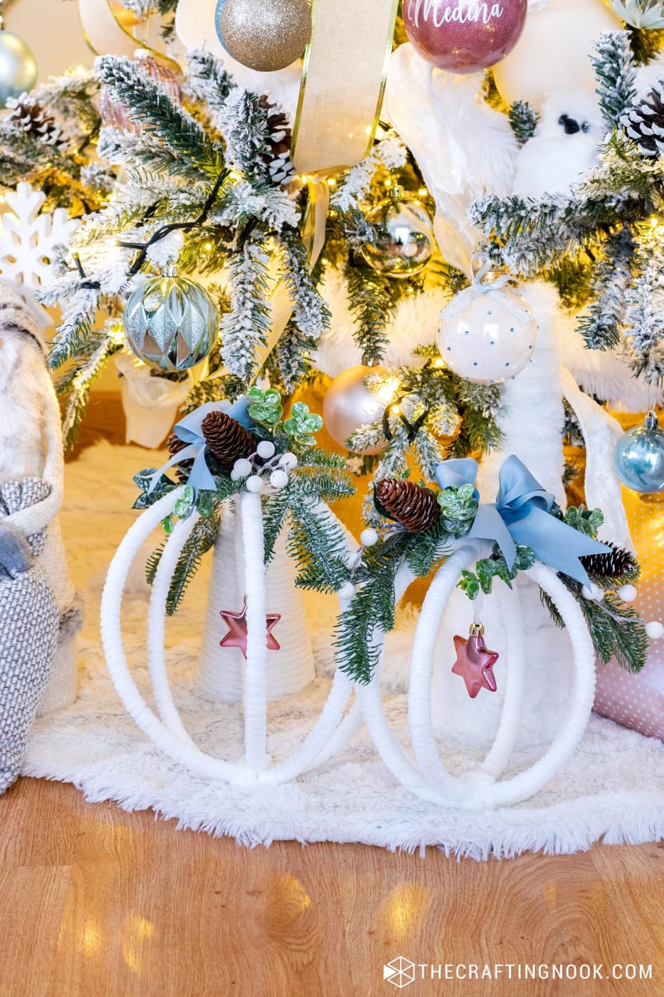 Large wrapped hoop ornament placed at the base of the Christmas tree beside gnomes and soft décor.