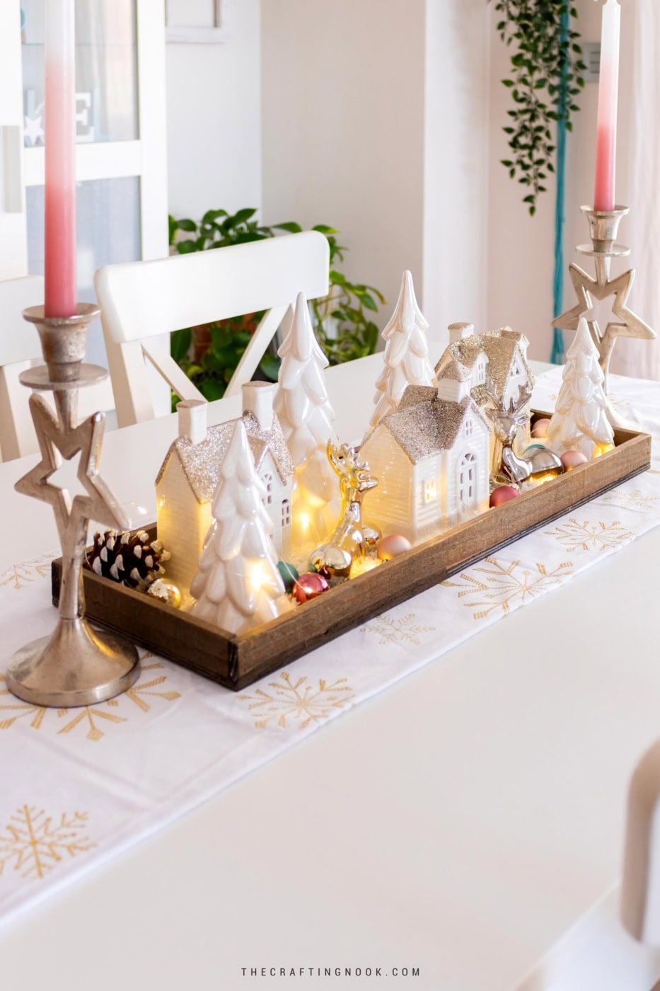 Side view of the winter village tray centerpiece with ceramic houses, trees, and fairy lights. Feature image.
