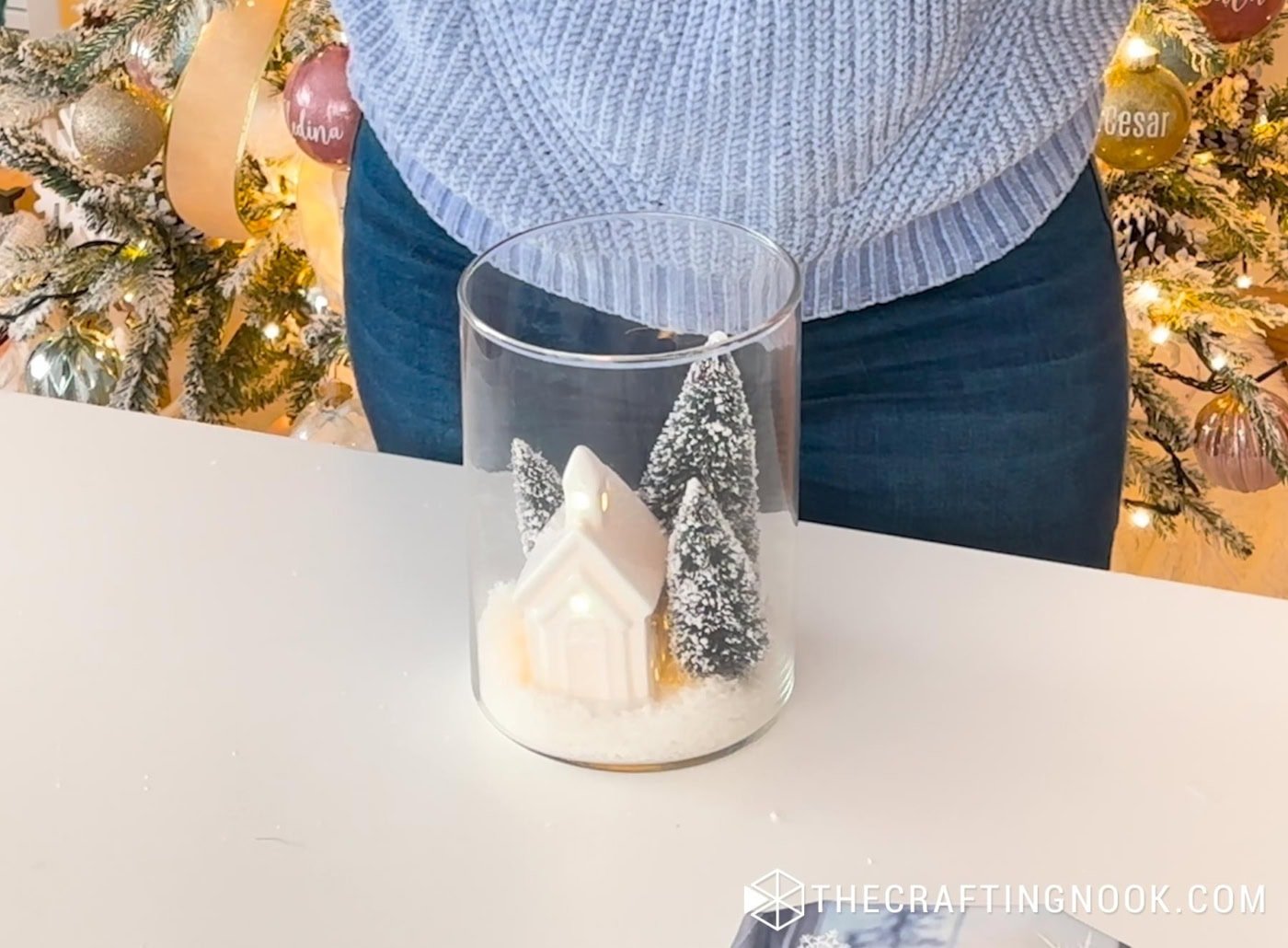 Side view of the snowy jar scene with the ceramic house glowing from LED tea light.