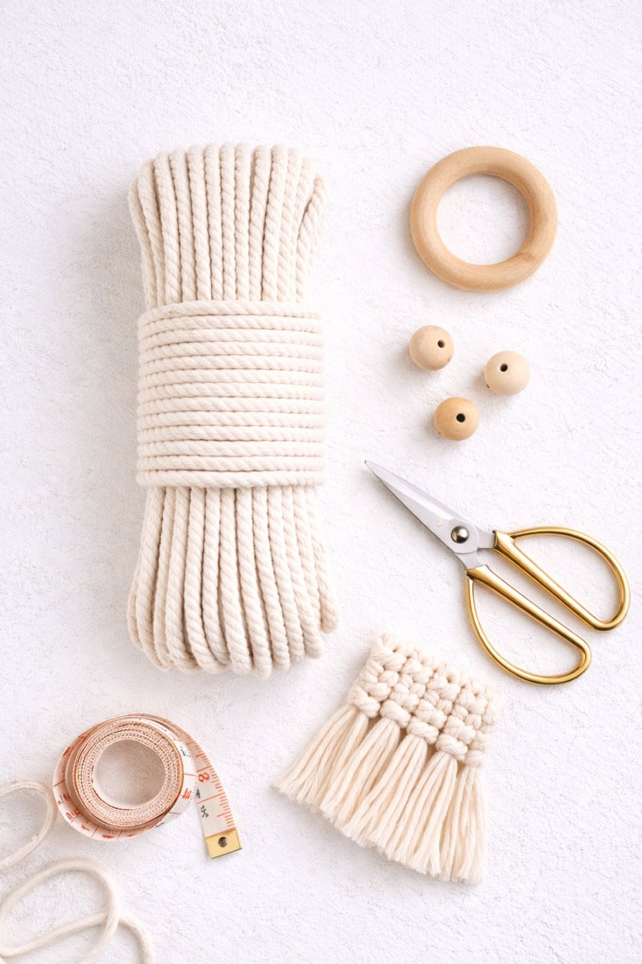 Macrame supplies including cords, wooden rings, and beads for beginners.