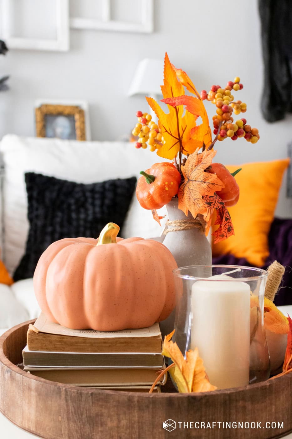Cozy fall decor with pumpkins and autumn leaves for seasonal home styling.