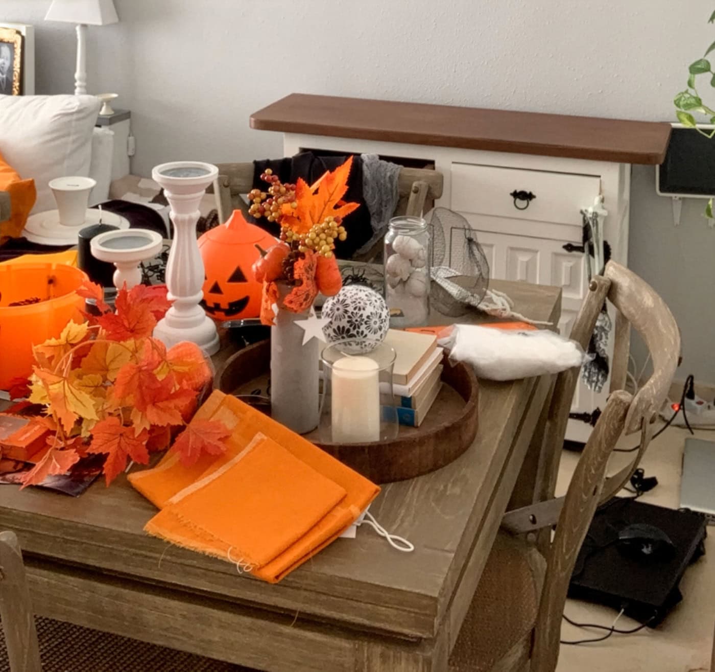 Fall-themed table decor with pumpkins, leaves, and candles for seasonal decorating.
