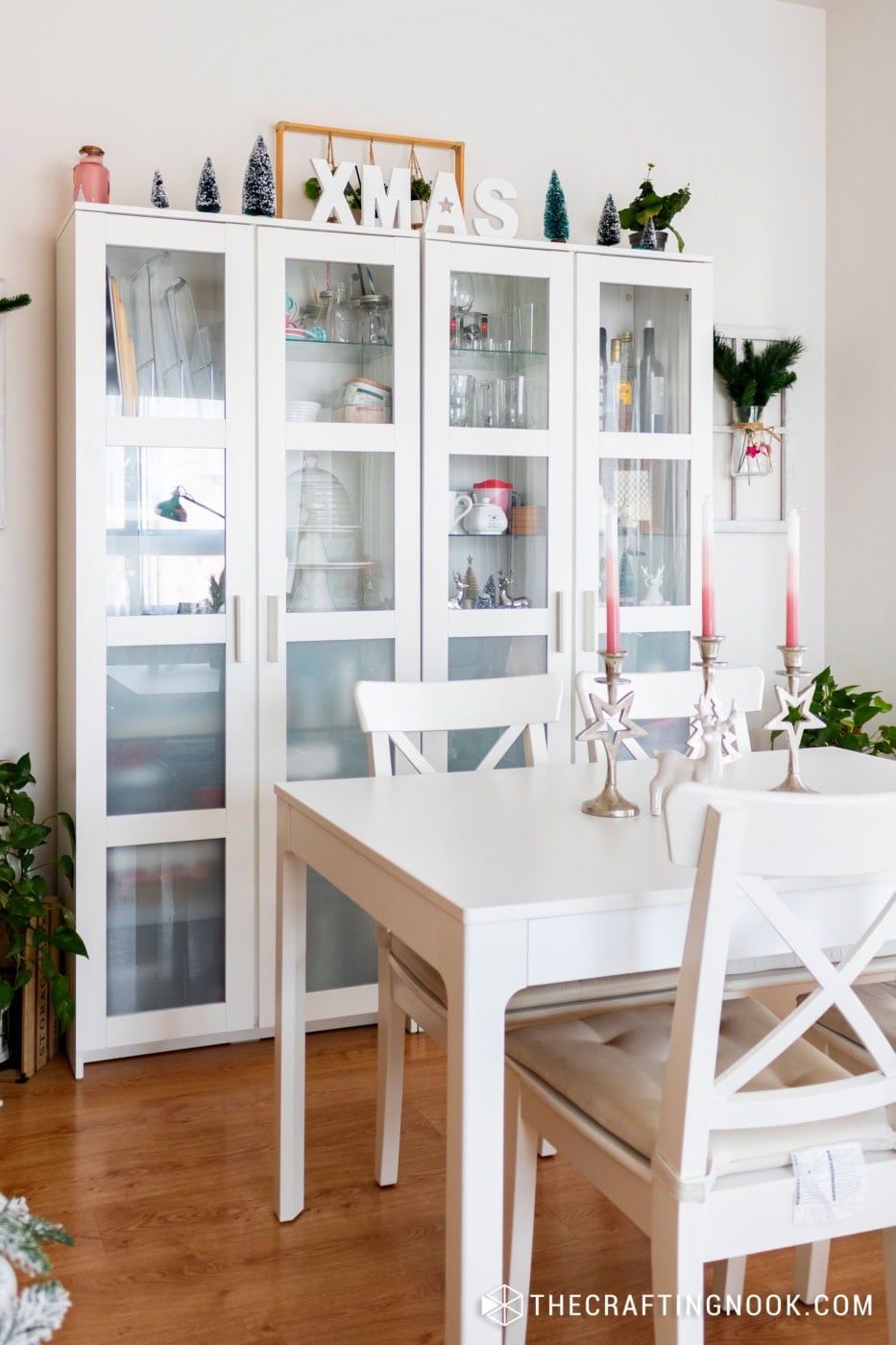 Bright white cabinet with glass doors showcasing holiday decorations.