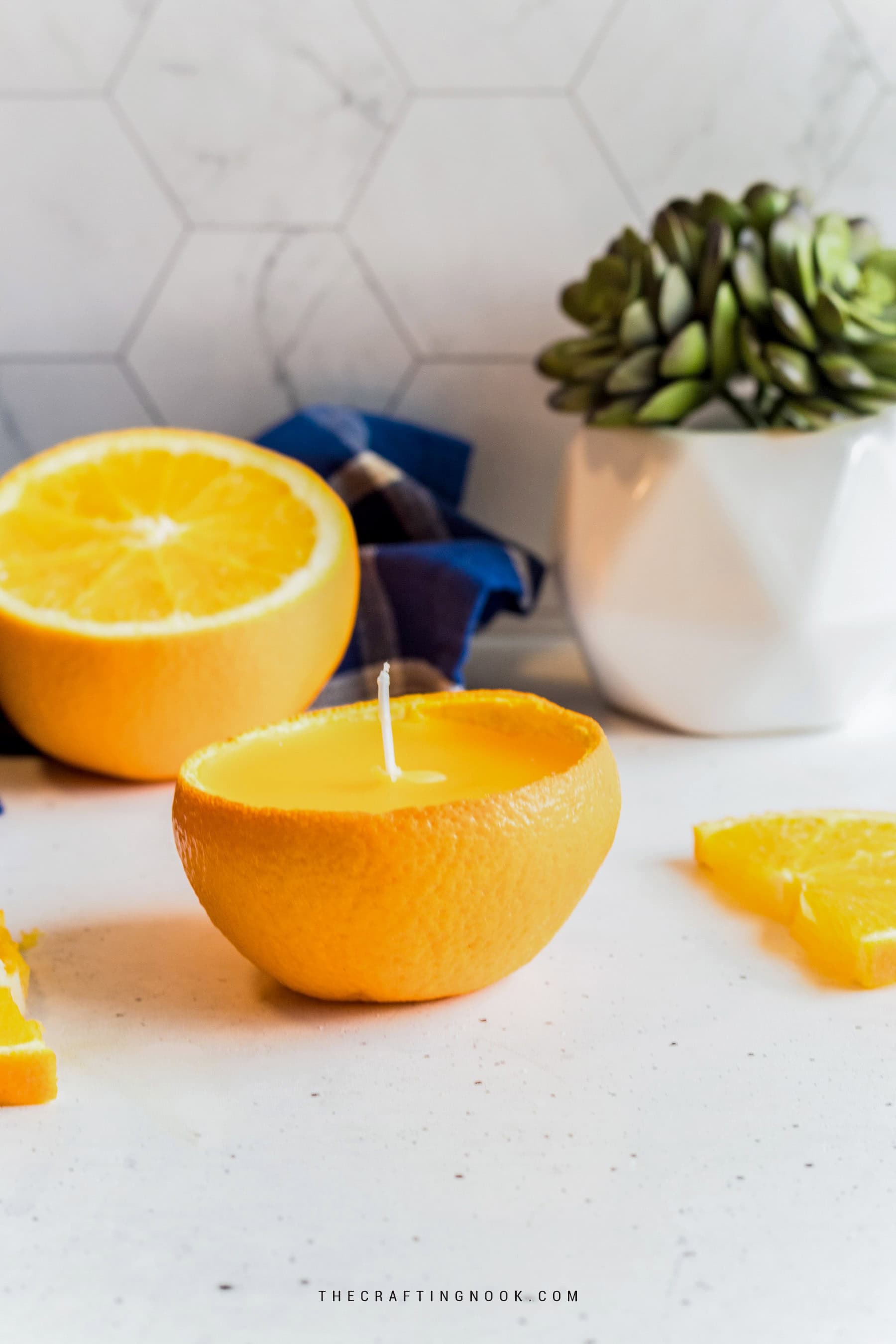 Citrus peel candle made from orange peel with lemon slices in the background.