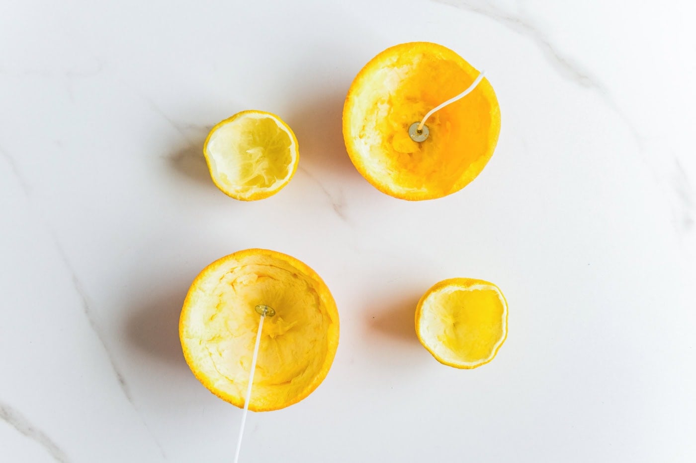 Pre-tabbed candle wicks placed in the center of hollowed orange and lemon peels.