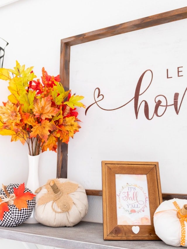 Autumn-themed home decor with pumpkins, leaves, and framed fall quote.