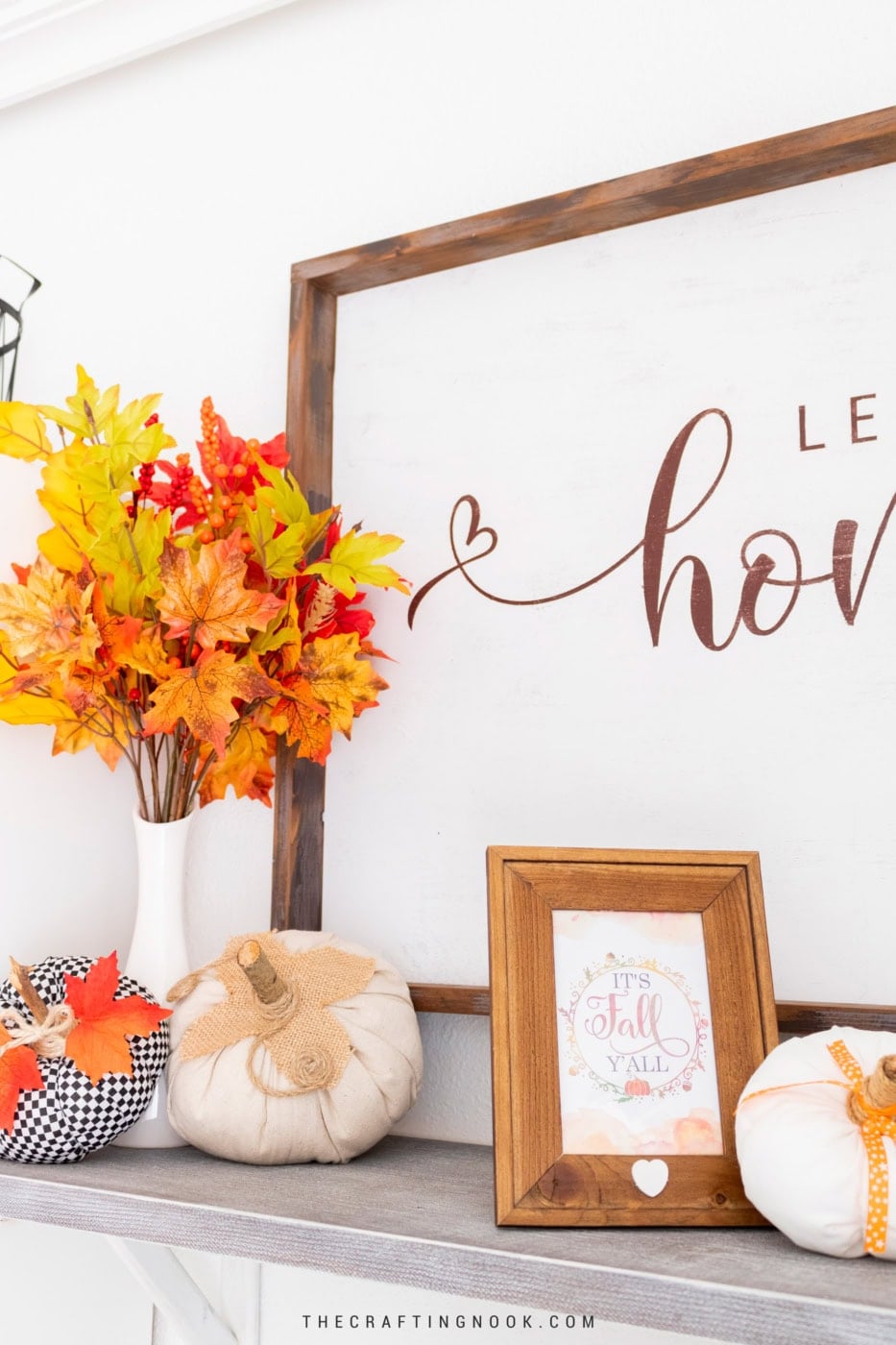 Autumn-themed home decor with pumpkins, leaves, and framed fall quote.