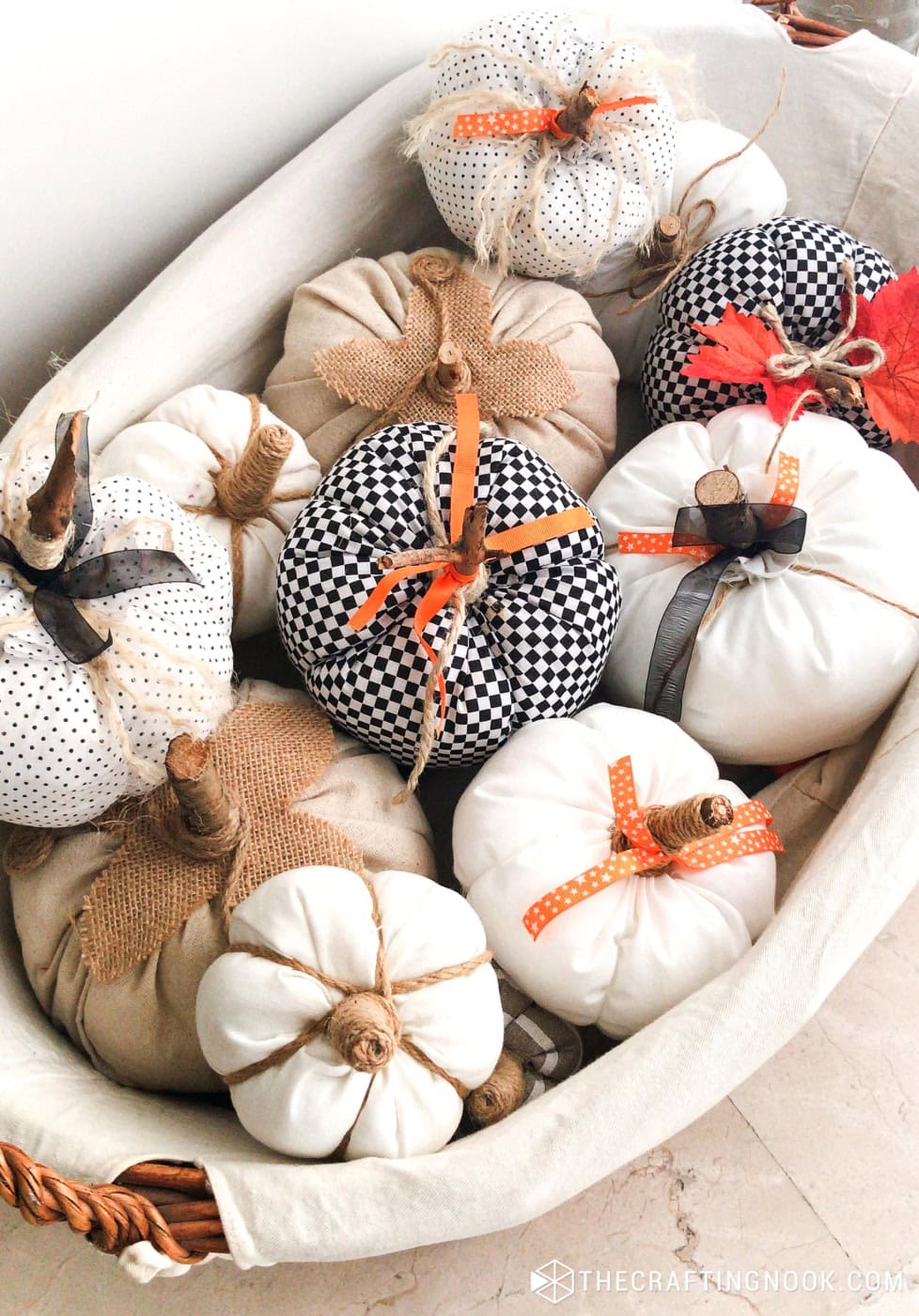 Basket filled with handmade fabric pumpkins in polka dot, checkered, and burlap fabrics for fall decor