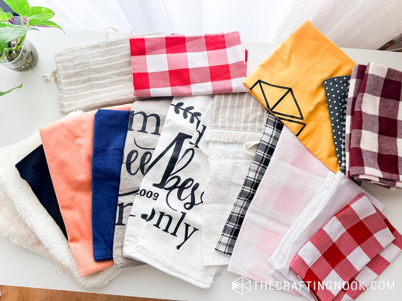 Flat lay of folded decorative pillow covers in assorted patterns, colors, and textures